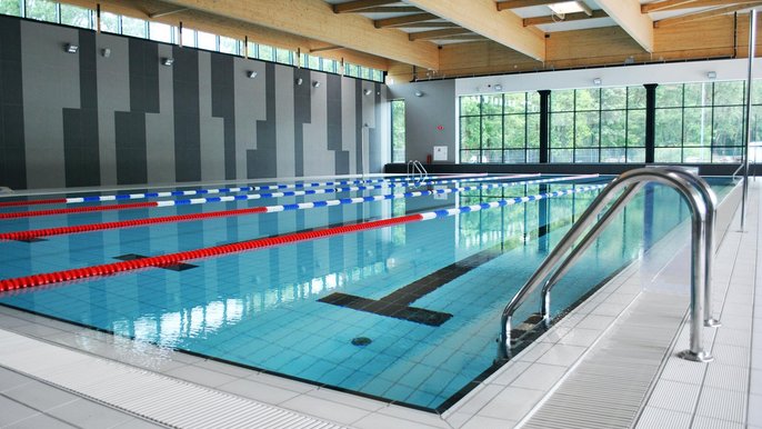 Wewnętrzny basen sportowy. Na pierwszym planie aluminiowa drabinka prowadząca do basenu. - Wewnętrzny basen sportowy. Na pierwszym planie aluminiowa drabinka prowadząca do basenu.